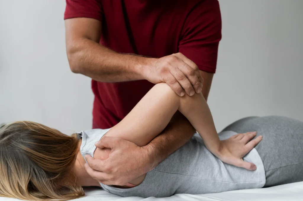 Fisioterapeuta flexionando la rodilla de un paciente tumbado en la camilla