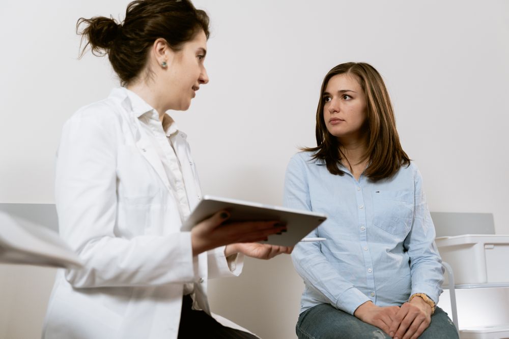 Profesional sanitaria atendiendo a una paciente en consulta